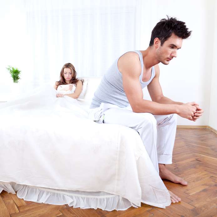 sexually dissatisfied couple - man with delayed ejaculation sitting on bed